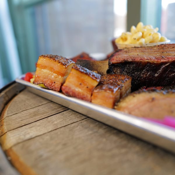 Close-up of LX BBQ's brisket, pork belly burnt ends, and mac and cheese on a metal tray.