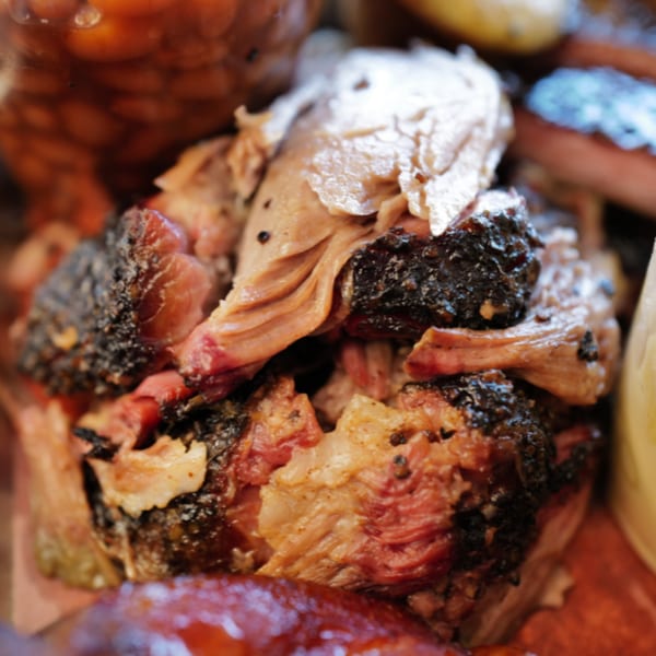 Close-up of juicy, smoked BBQ brisket with crispy burnt ends and tender pulled meat.