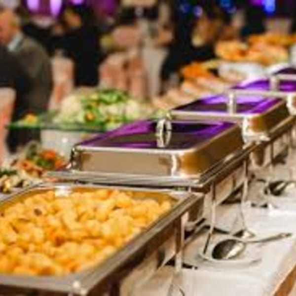 A buffet line with chafing dishes filled with food, including golden fried items and salads.
